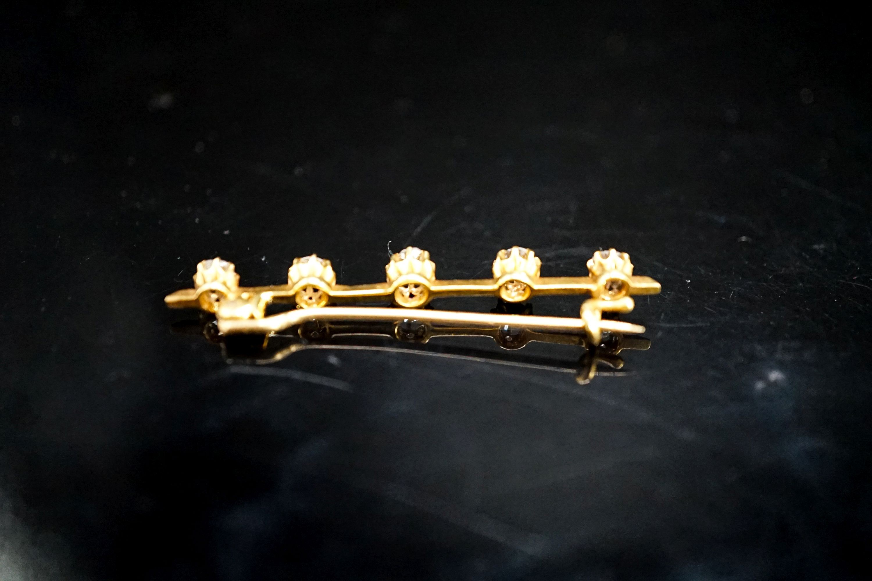 A yellow metal and five stone diamond set bar brooch, 45mm, gross weight 2.8 grams.